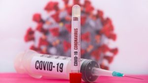 Covid-19 needle tubings and corona virus at the background