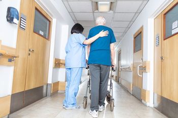 A nurse is helping a senior walking in nursing home