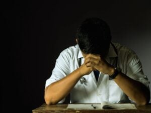 a doctor with hands on his head and looked depressed