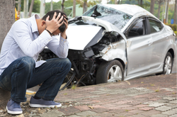 a crashed car and a worried man.png
