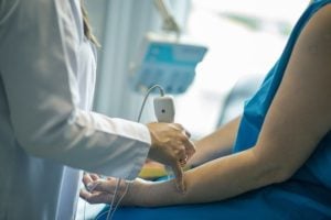 Doctor is using medical equipment to diagnose a patient