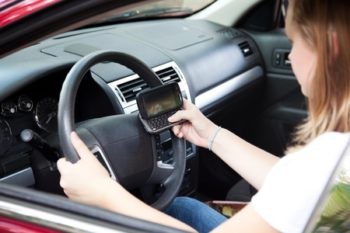 A young lady texting while driving
