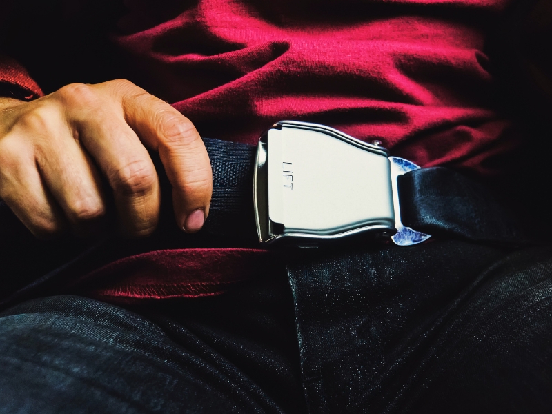 Male passenger releasing seat belt while sitting on the airplane preparing to get off. concept of a safe flight. safety while driving. turbulence during flight

